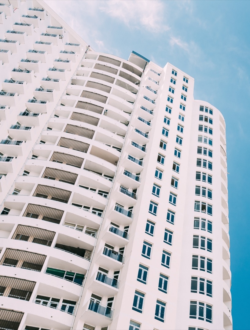 Wall With A Balcony Of New Modern Multi-storey Residential Building House In Residential Area On Sunny Blue Sky Background